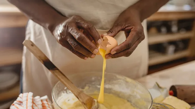 Health: Diet and nutrition: closeup woman cracking egg into bowl 1179997283