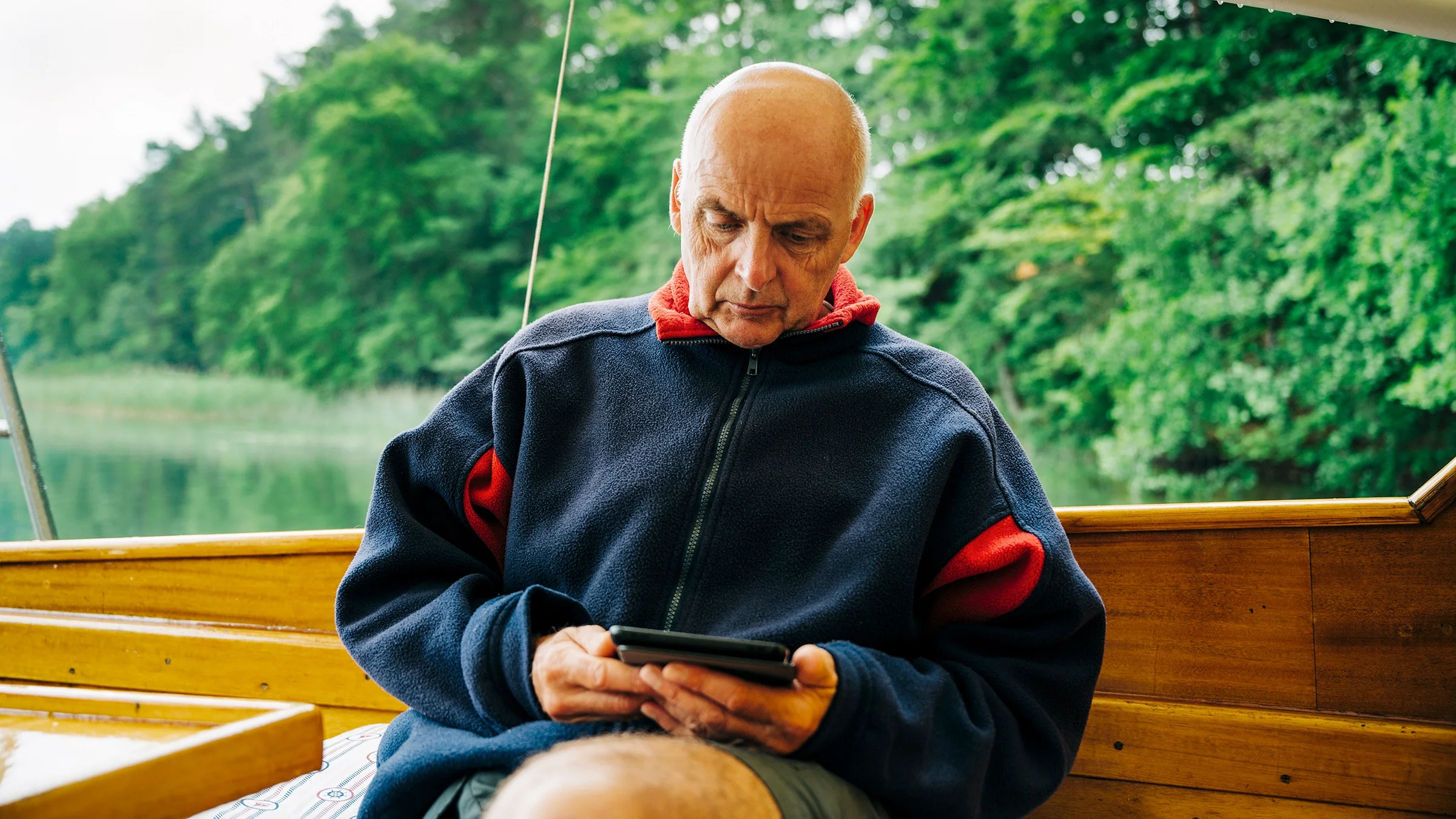 Senior man reads an e-book while sitting outside