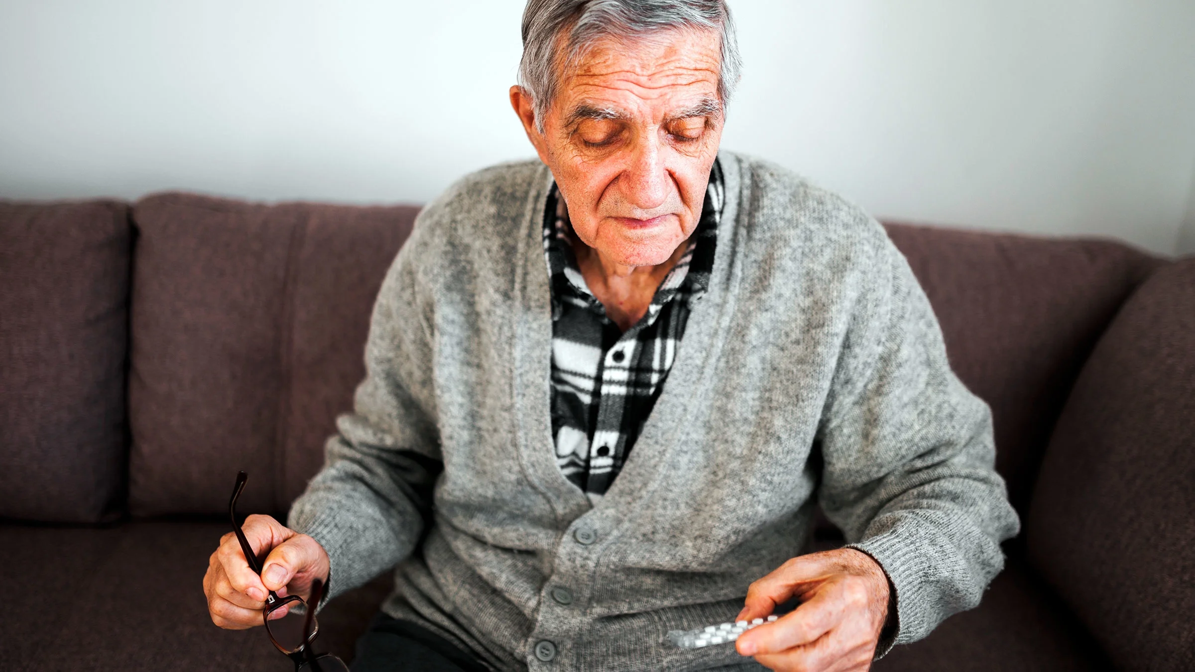 A senior man with a blister pack of medication.
