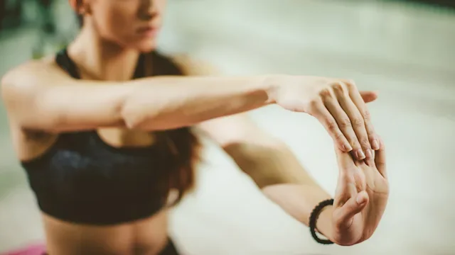 Movement exercise: Stretches: woman doing wrist stretches-530994014