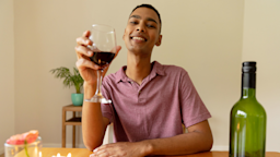 A man holds a glass of red wine and smiles at the camera.
Wavebreakmedia/iStock via Getty Images Plus