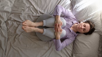 Movement-exercise: woman knee to chest pose in bed 1225255351