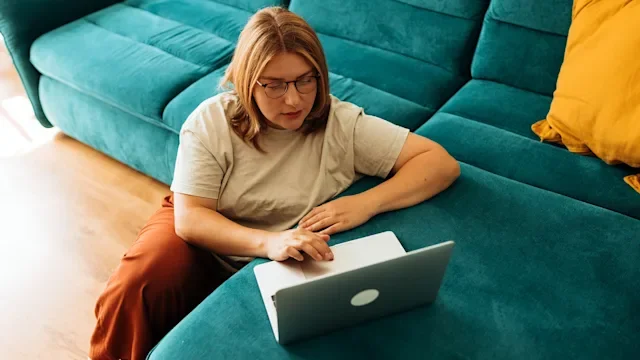 GLP 1 agonists: woman using laptop at home 2164478927