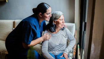 Caregiving: senior woman with home caregiver 1761327612