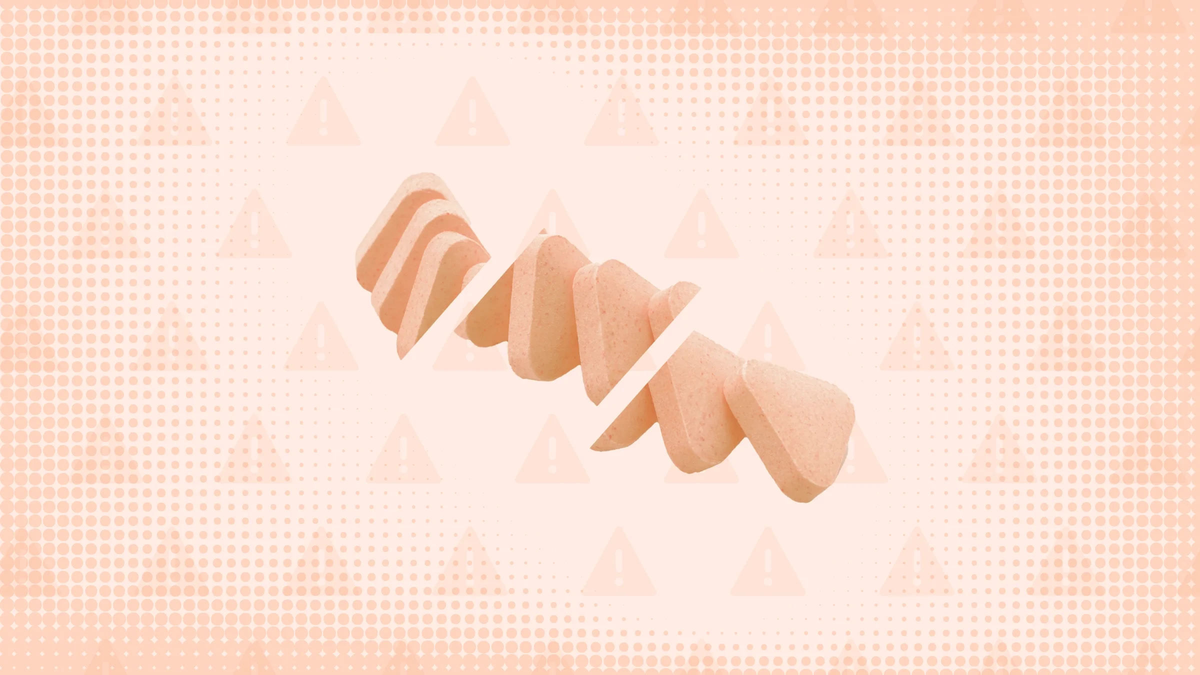 Light-orange background with texture and warning sign pattern. In the center is a row, cut into thirds, of orange triangle-shaped pills. 