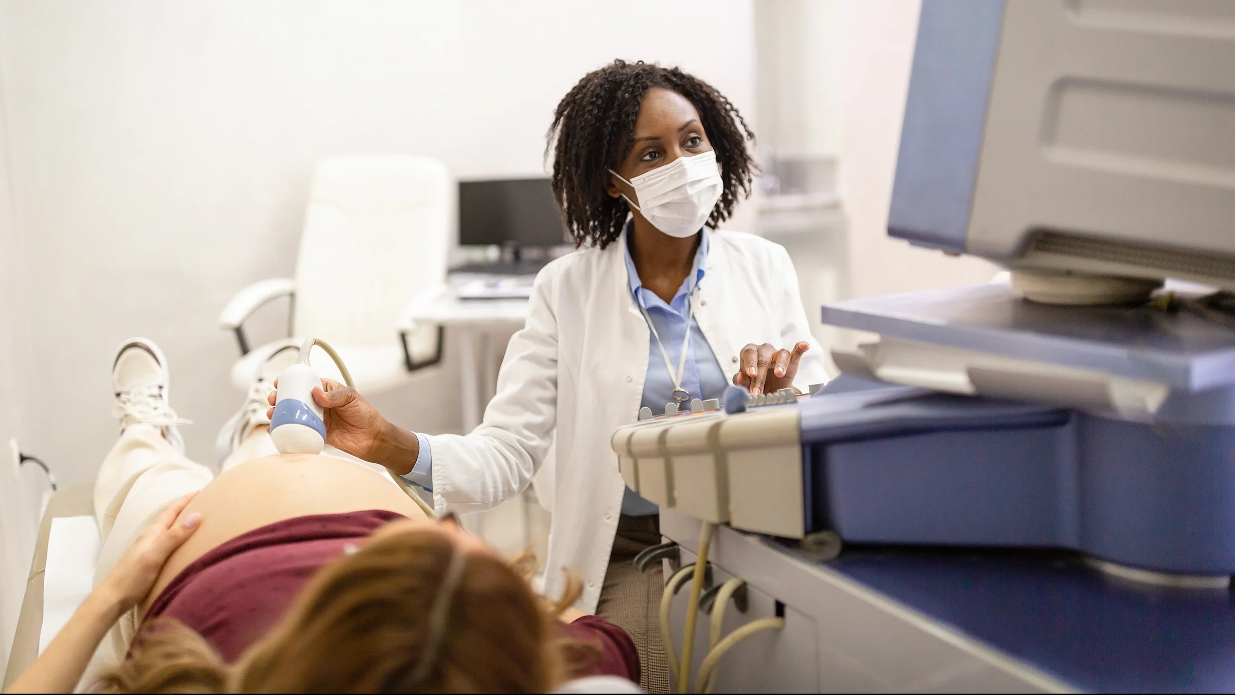 A technician is performing an ultrasound for a pregnant woman.
