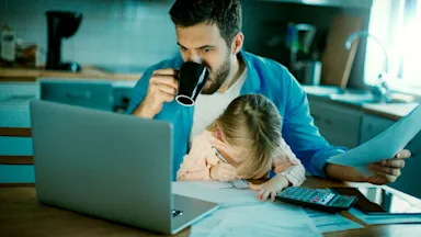 drinking coffee going through bills child on lap-509658052