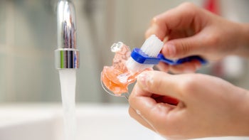 Dental Care: Oral: closeup brushing dental retainer 1357905317