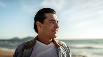 Health: Stress: man smiling on beach 1442574141