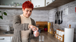 An older woman takes medication with a glass of water.
Marko Cvetkovic/E+ via Getty Images