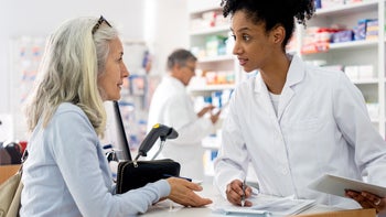 Medicare: woman speaking to pharmacist 1439988853
