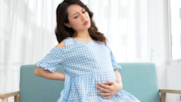 A pregnant person holding their belly in discomfort.
SunnyVMD/iStock via Getty Images Plus