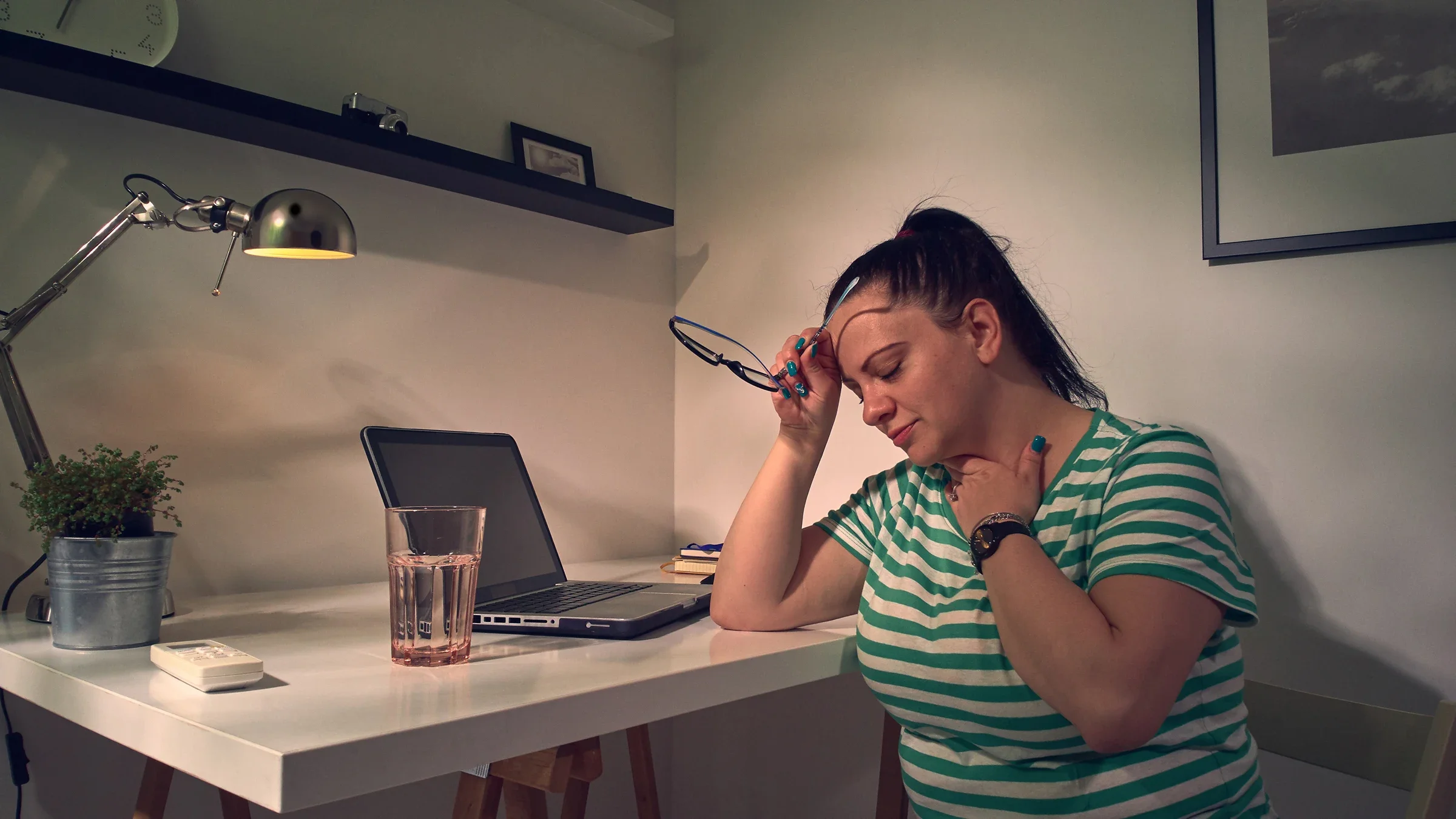 Woman with neck pain leaning on a desk.
m-gucci/iStock via Getty Images Plus
