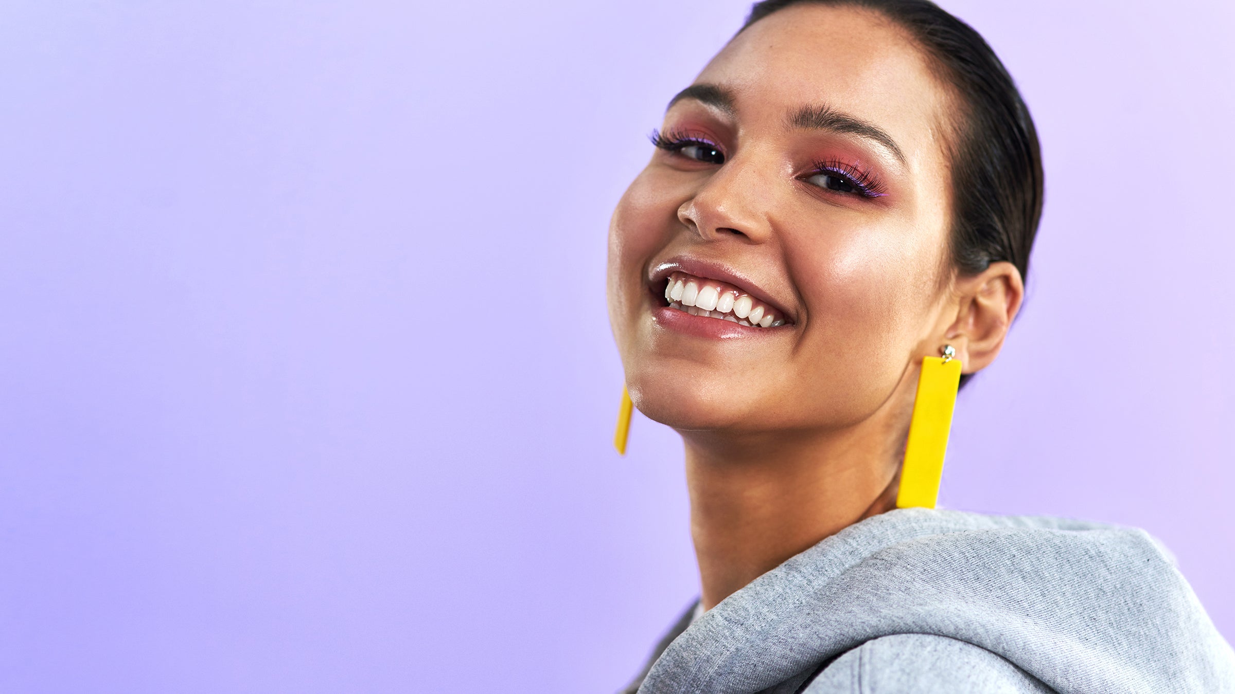 portrait woman with short hair purple gradient background yellow earrings 1295760261