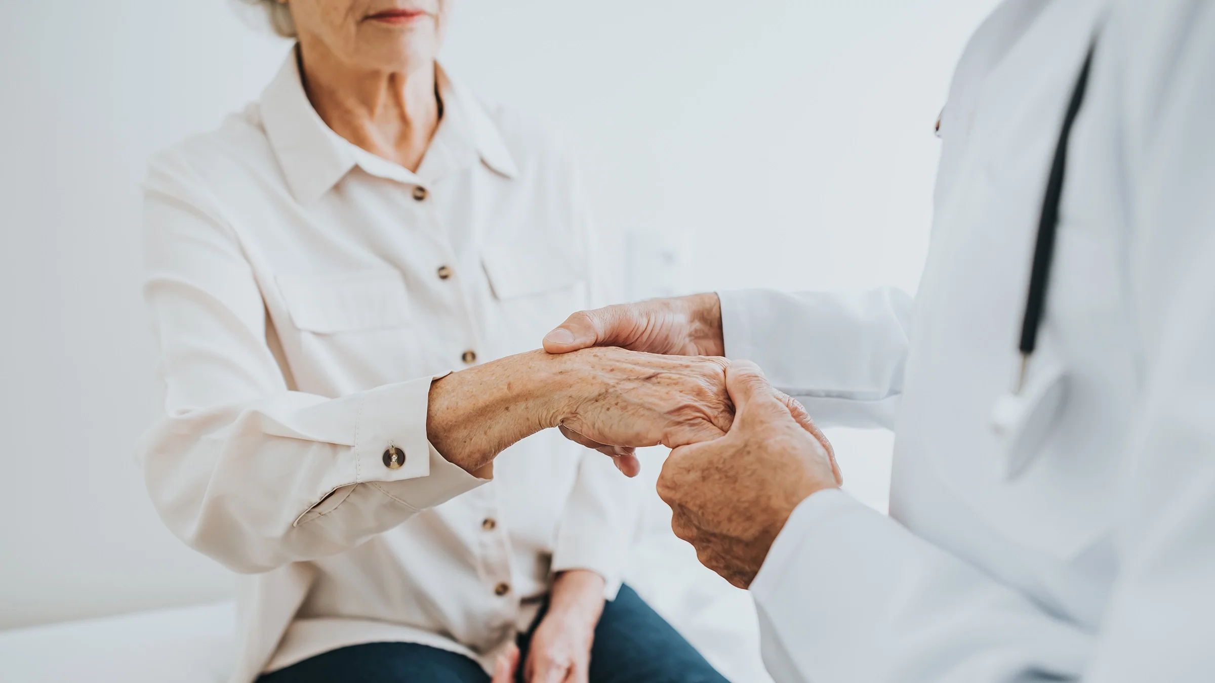 A doctor examines a woman's wrist during an appointment.