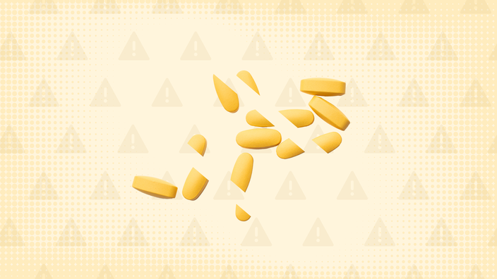 Light yellow background with texture and warning sign pattern. In the center is a pile of yellow pills cut into thirds. 