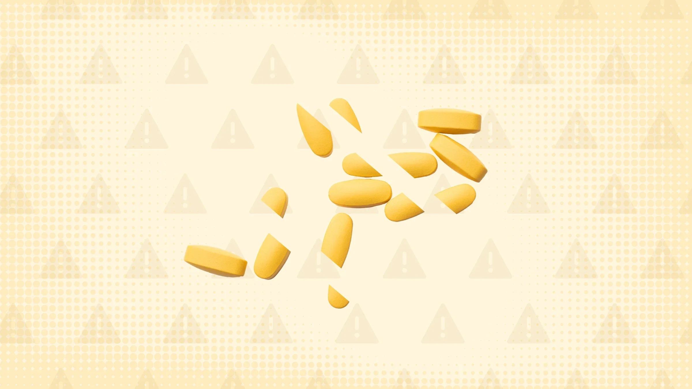 Light yellow background with texture and warning sign pattern. In the center is a pile of yellow pills cut into thirds. 
GoodRx Health