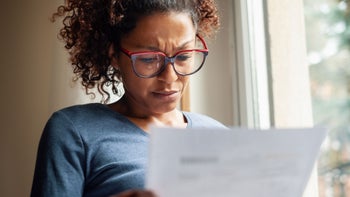 Research: Medicare Part D: woman reading paperwork 1054665100