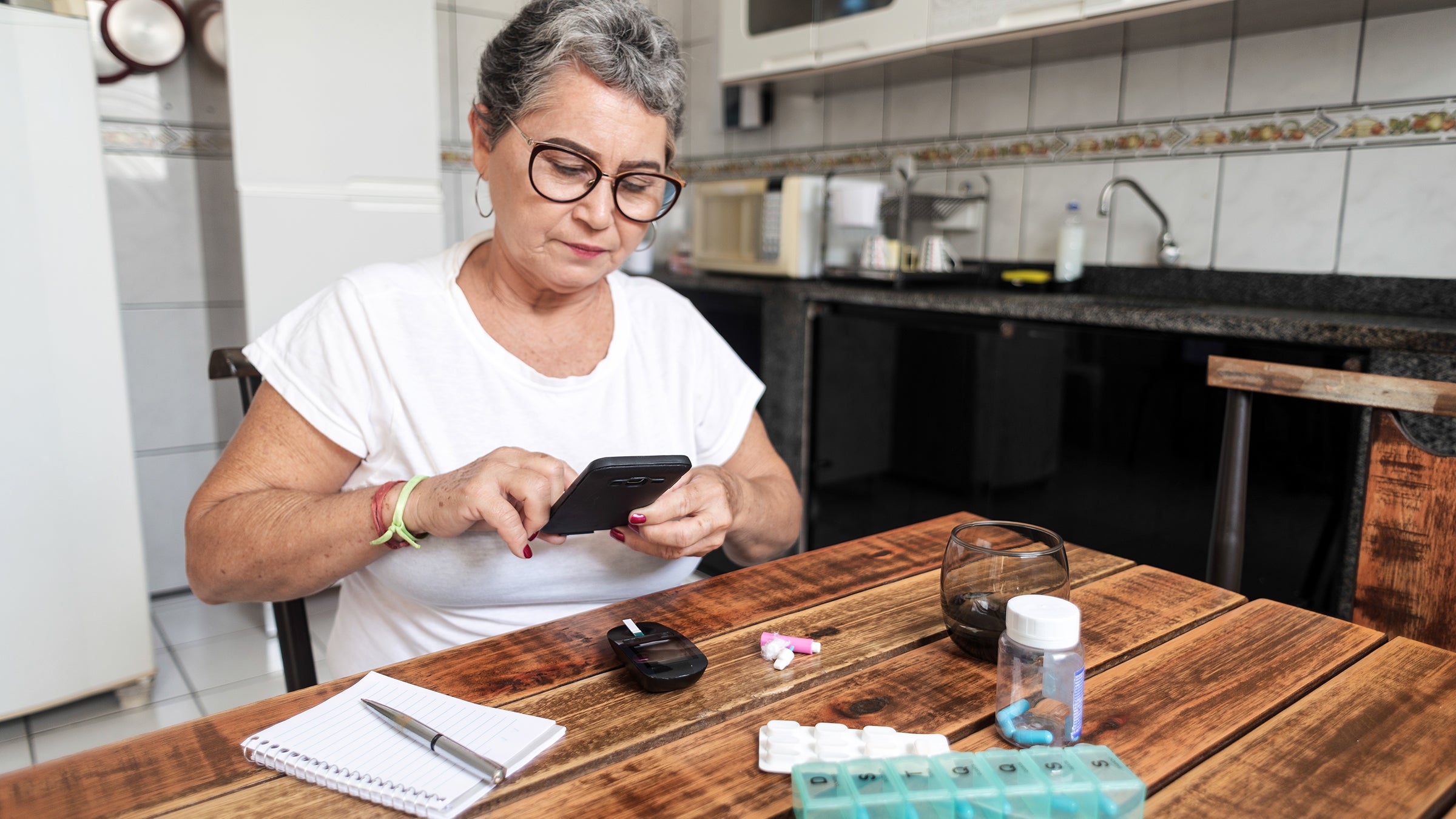 Diabetes: senior woman recording blood sugar level 1294312051