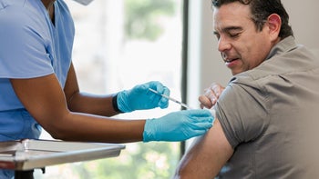Pharmacy: man receives injection in upper arm 1404901970