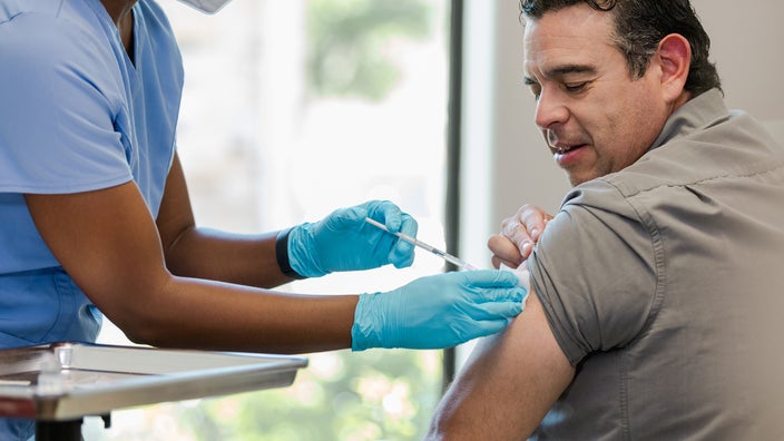 Man receives injection in his upper arm.
