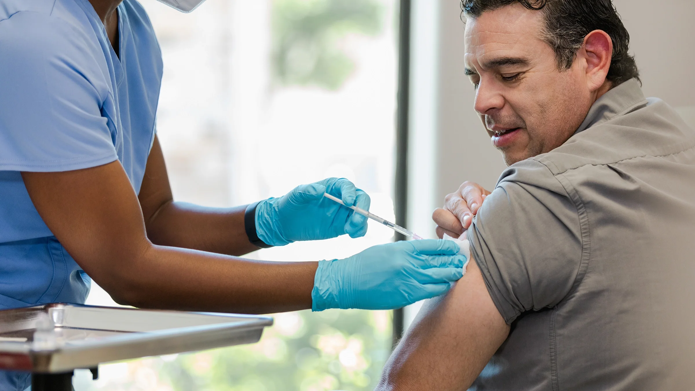 Man receives injection in his upper arm.