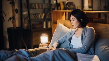 Health: Covid 19: young woman working from bed 1368328430