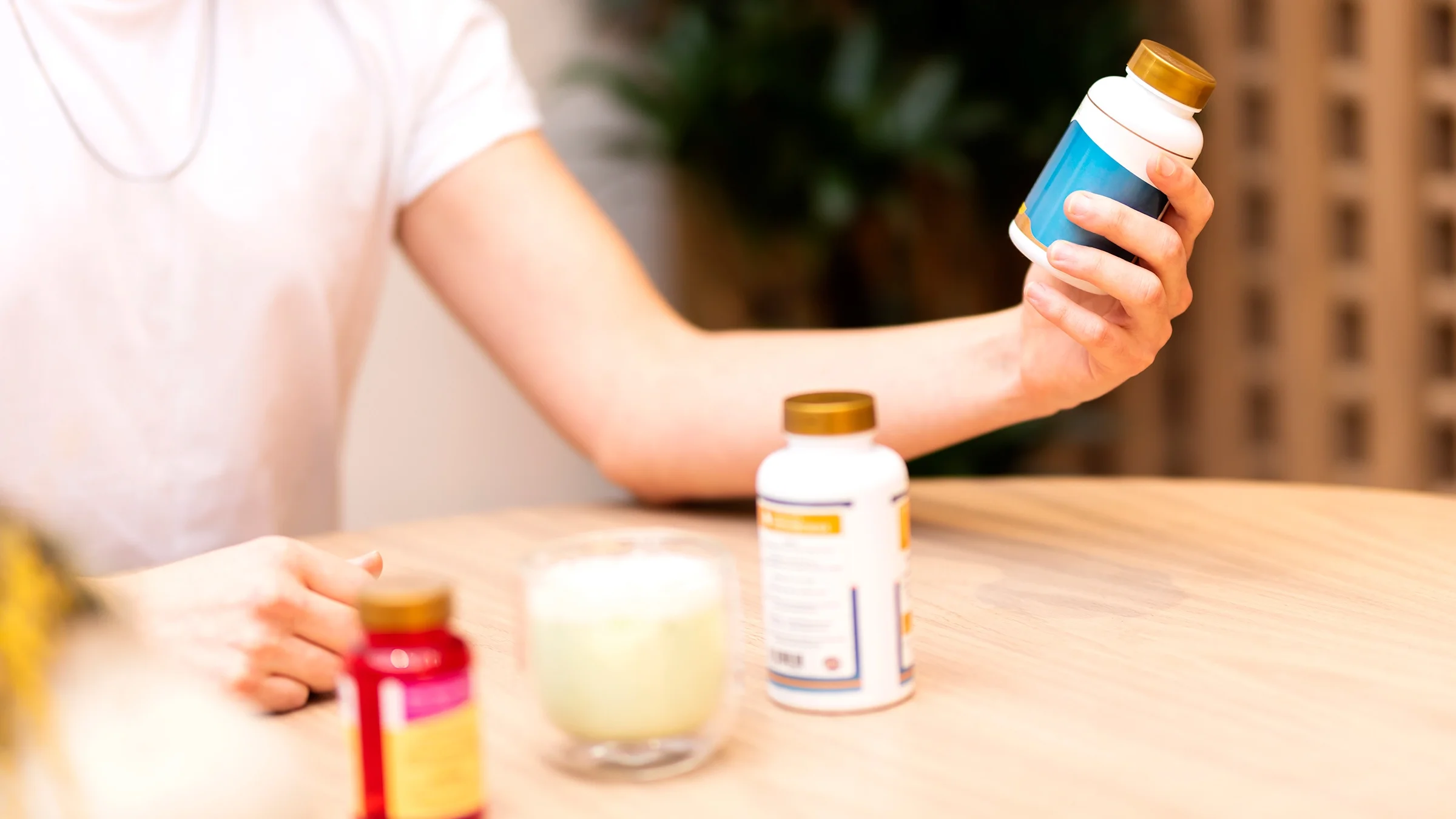 A person holds a bottle of vitamins.