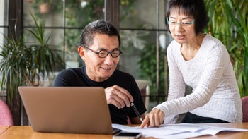Medicare: couple looking at digital and paper documents 1180368785