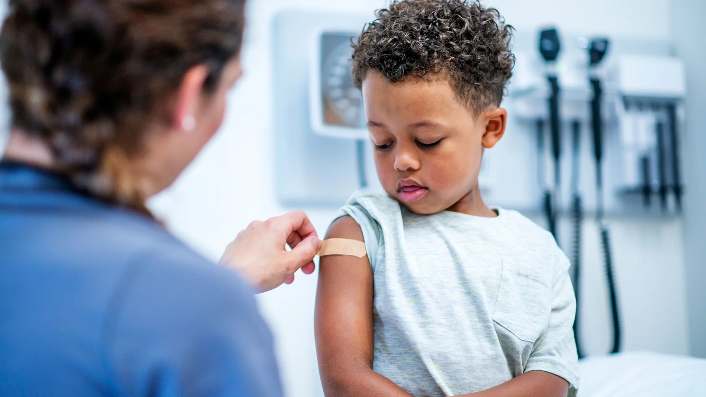 Child with bandaid on arm after a vaccine.