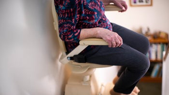 Medicare: Stair lift: closeup woman on stair chairlift 1088937602