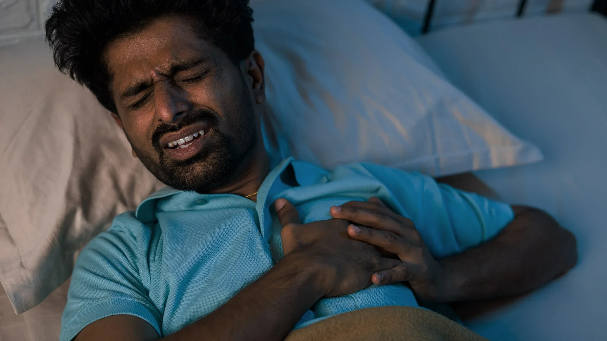 A person experiencing chest pain while trying to sleep.
lakshmiprasad S/iStock via Getty Images Plus  