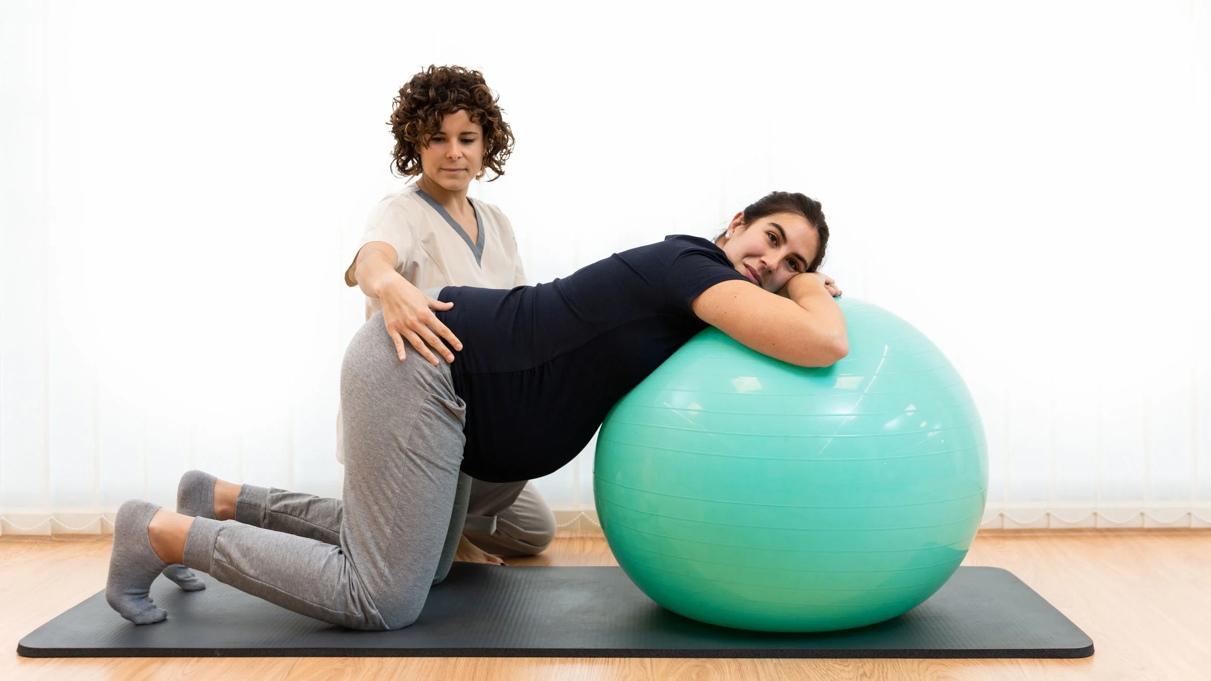 Pregnant woman doing pelvic exercise on a stability ball.