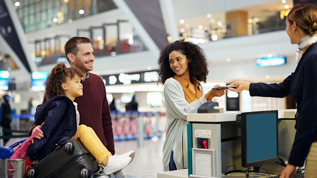 children's health: parents and child checking into a flight 1485095338