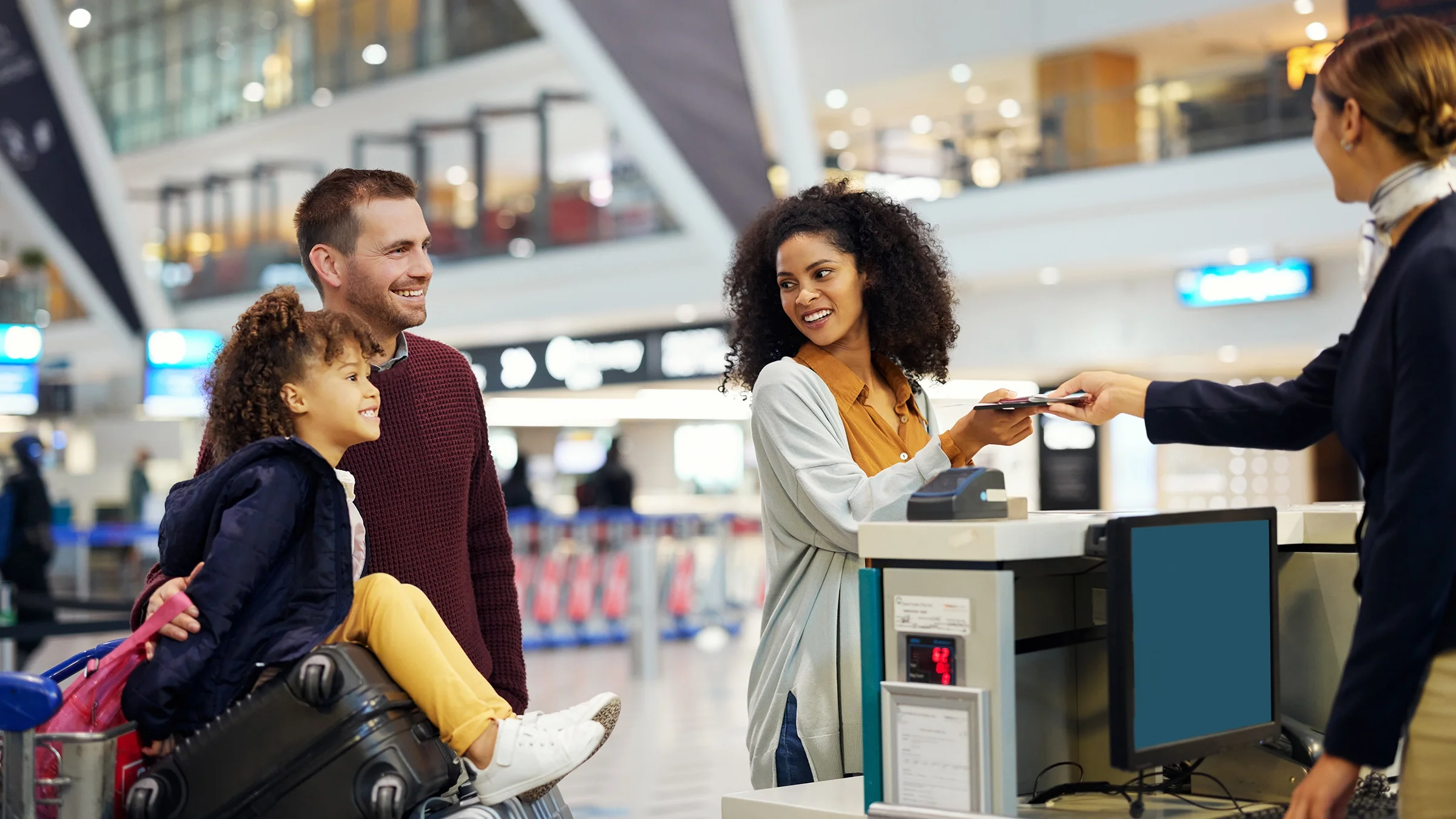 Parents and child checking into a flight at the airport.