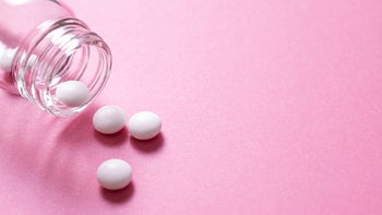 Health: emergency contraceptive: white pills pink background glass bottle-1339372592