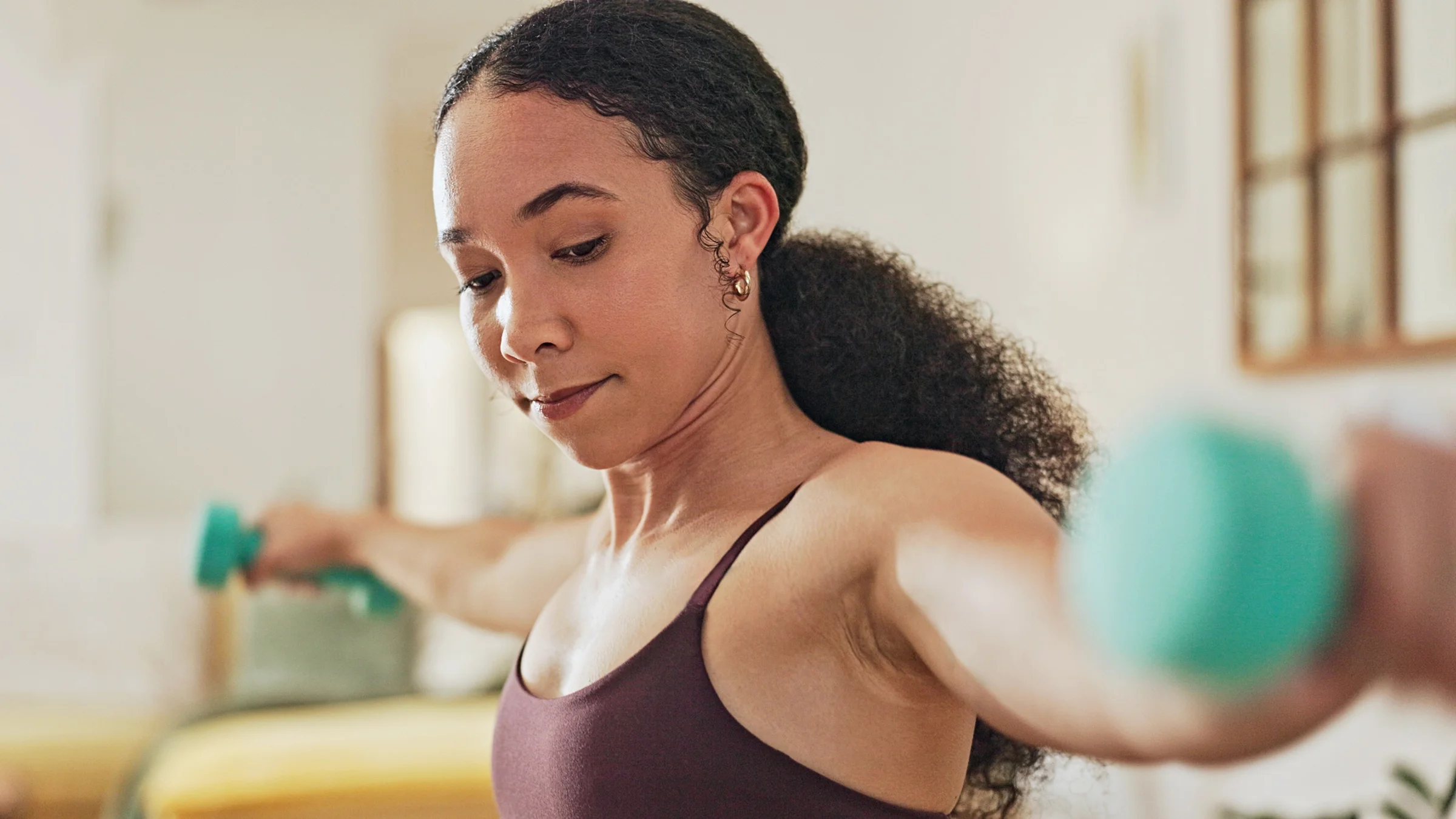 A woman exercises with weights.