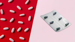 Half of the frame is pink Pepto Bismol pills on a red background. the other half of the frame is Imodium pills on a pink background.
anilakkus/iStock via Getty Images
