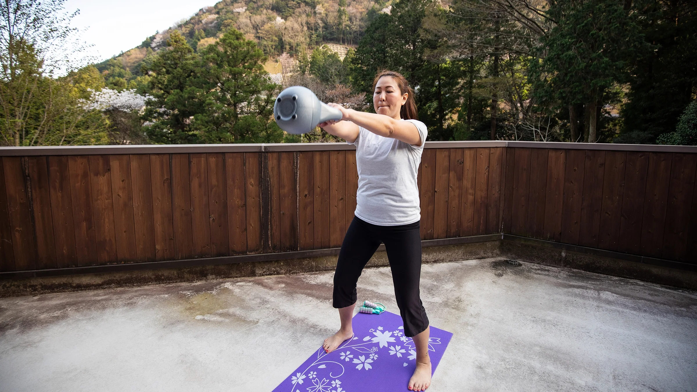 A woman does a kettlebell workout at home.