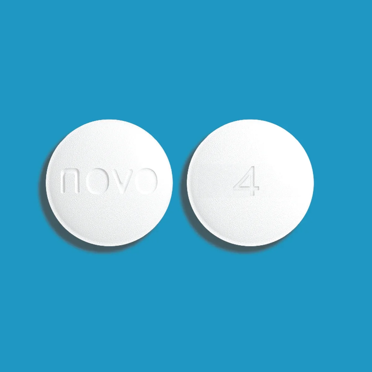 Blue background with white round Novo Nordisk Wegovy 4mg pill, front and back.