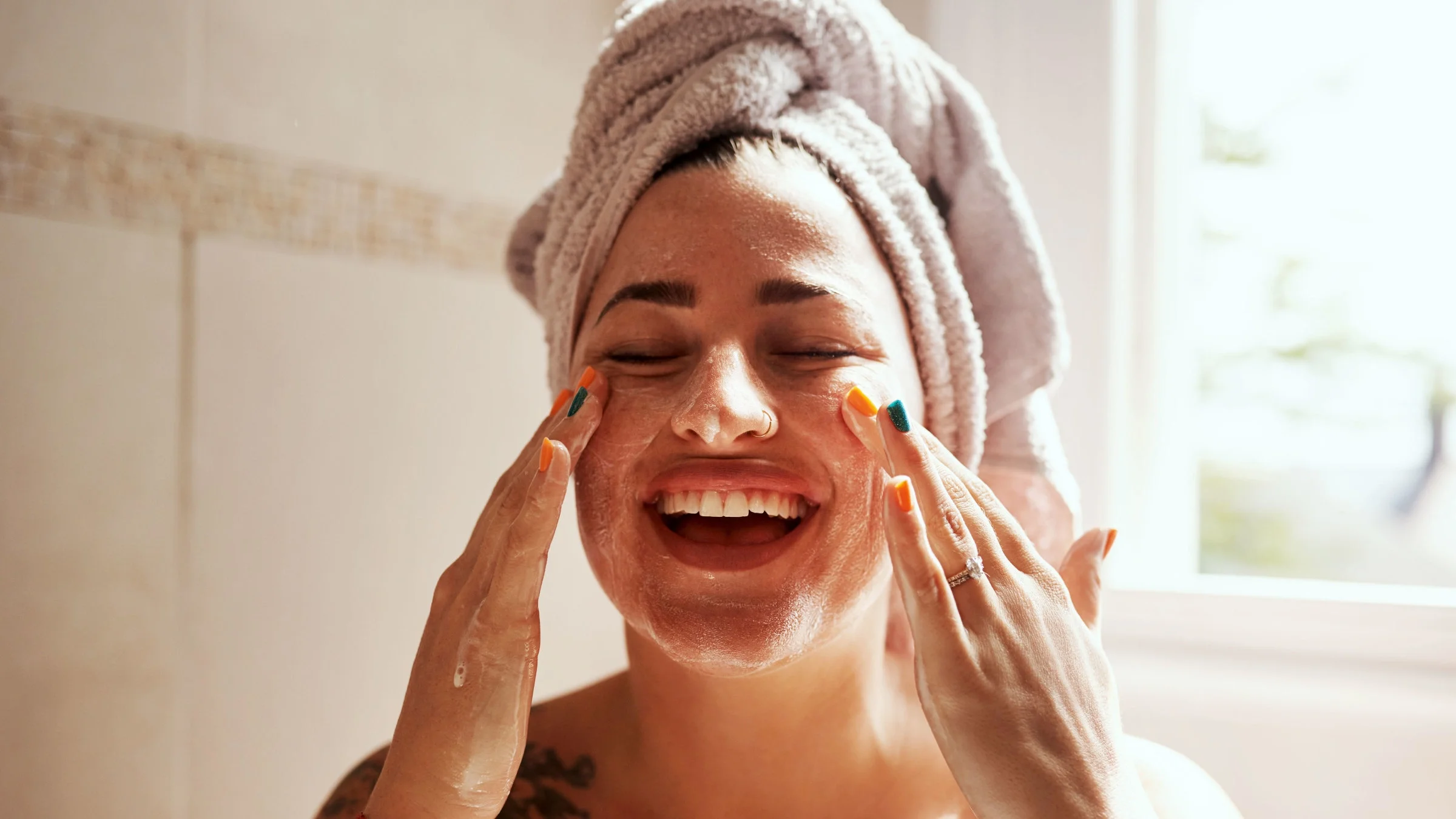Woman washing her face in bathroom.