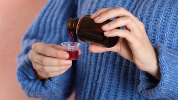 Pharmacy: closeup pouring cough medicine in cup 1453294951