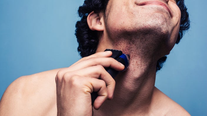 A man shaves with an electric razor. Shaving can lead to razor bumps. But there are ways to get rid of razor bumps, such as creams and keeping your skin clean and moisturized.