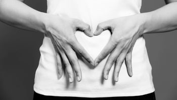 Gut health: cropped shot hands making heart on stomach-864494020