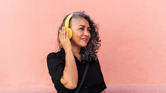 Health: Mental health: woman with headphones against pink wall 1438271833