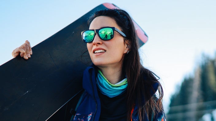 A portrait of a snowboarder with sunglasses on.