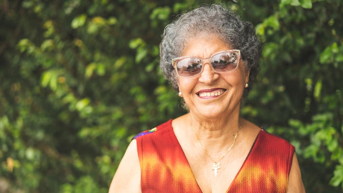 Portrait of a senior woman outside wearing sunglasses.