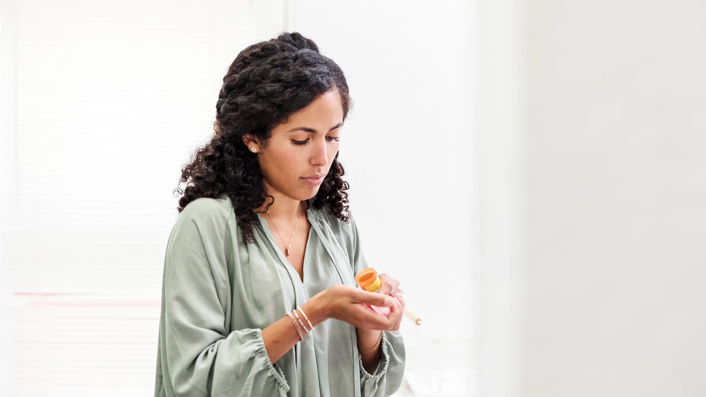 A woman is counting out pills from a medication bottle. 