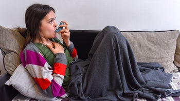 Asthma: using inhaler on couch 1150948165