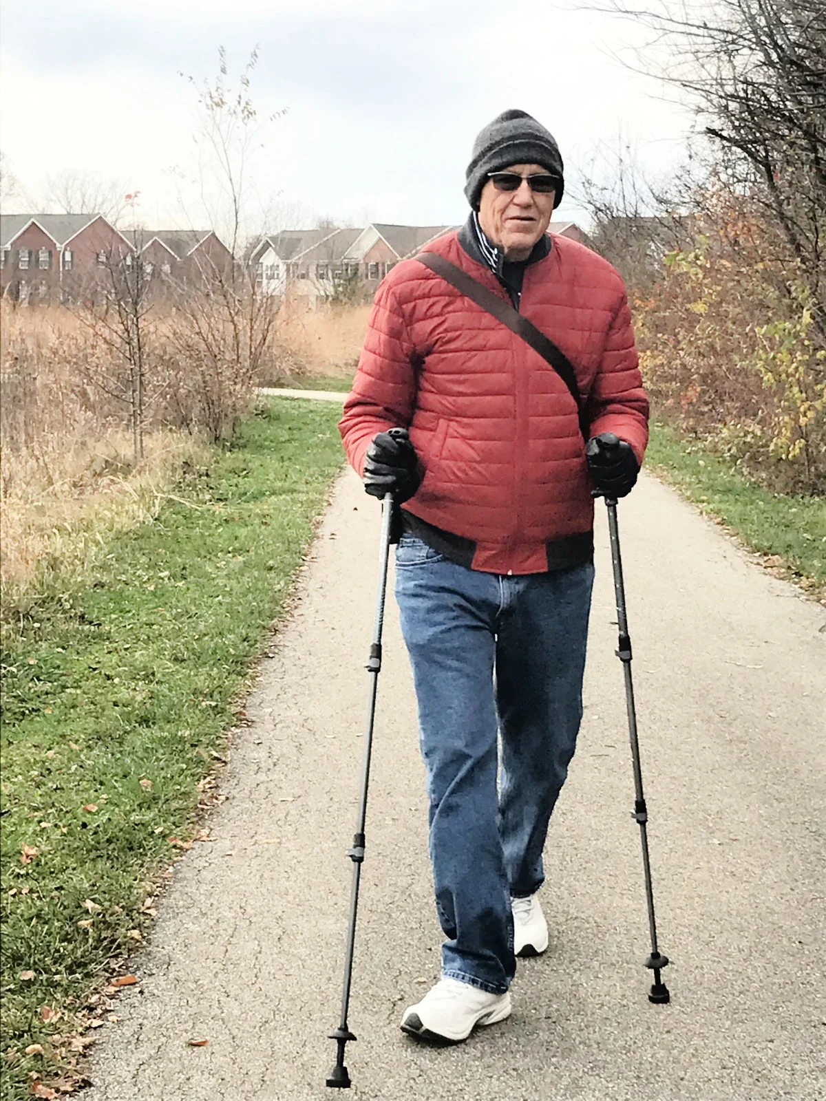 Rick Phillips is pictured using walking sticks on a walking trail.